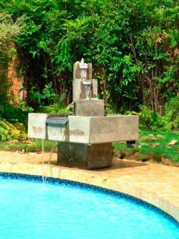 fuente de agua moderna con cascada en la piscina