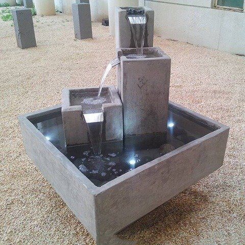 fuente en cemento moderna con varias luces
