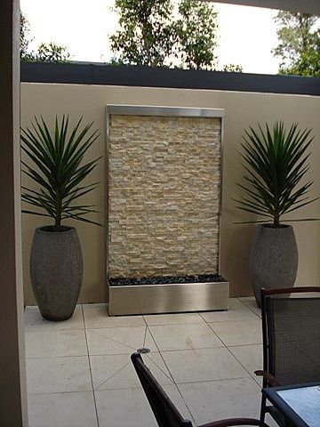 fuente de pared moderna para patio con jarones de plantas decorativos