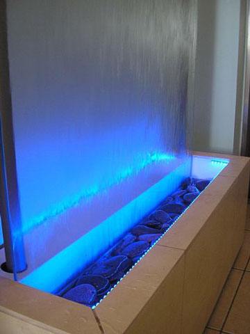 fuente de pared moderna con cascada lenta y luces azules espectaculares